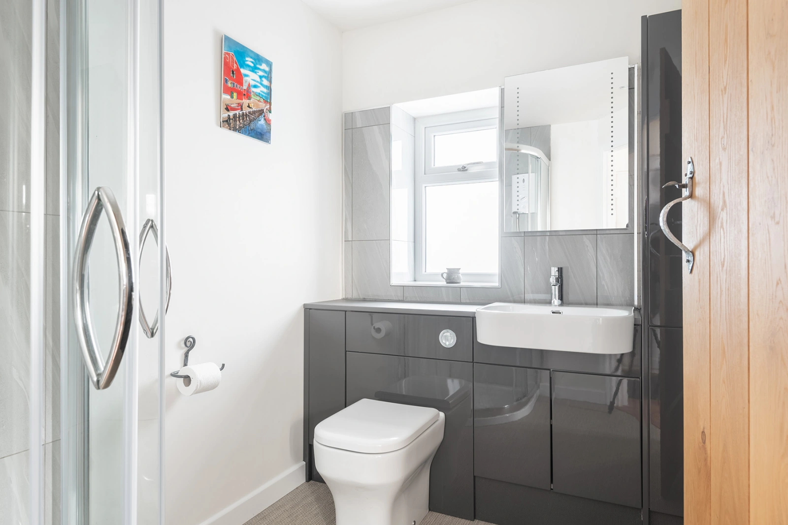 The shower room looks very modern & stylish and has a corner shower cubicle.