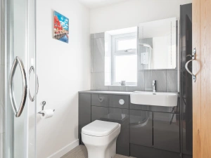 The shower room looks very modern & stylish and has a corner shower cubicle.