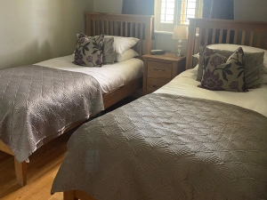 Twin beds, wardrobe and a bedside table with a lamp - Kingfisher Lodge