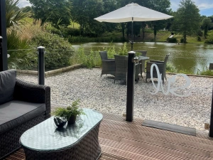 Outdoor area with seating and views to the pond - Kingfisher Lodge