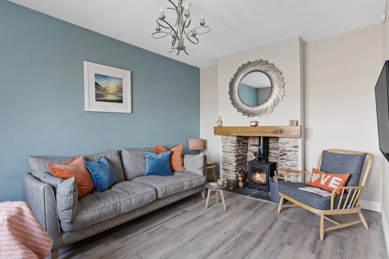 Living room with cosy log burner, sofa and arm chair - Bumble Cottage