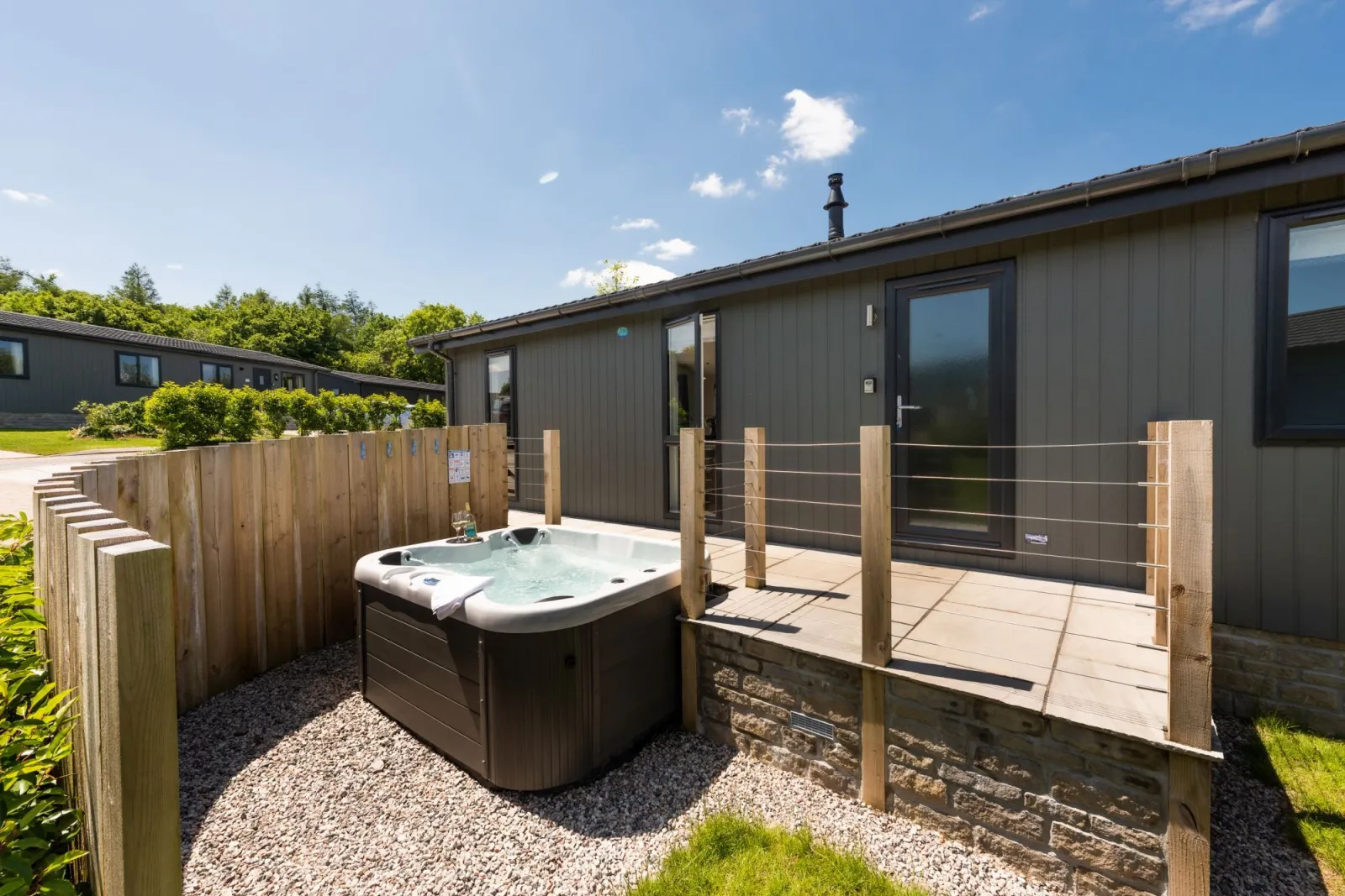 The hot tub with a privacy screen - Buttercup Lodge 