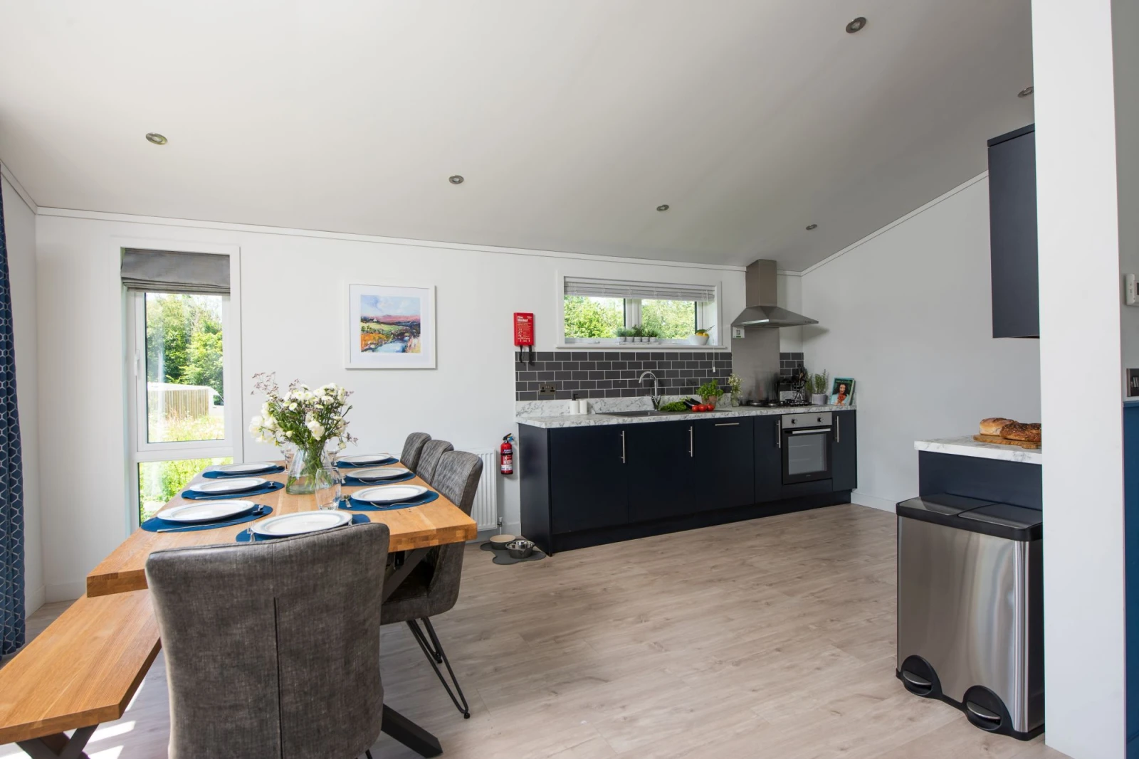 The dining table with seating for all guests and kitchen - Buttercup Lodge 