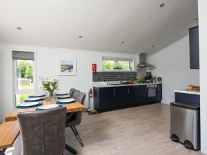 The dining table with seating for all guests and kitchen - Buttercup Lodge 