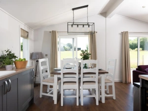 A dining table and chairs for all guests to eat together or play games - Forget Me Not Lodge 