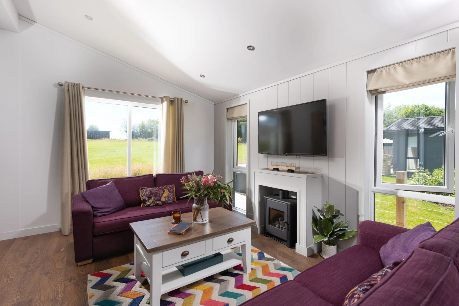 Comfortable sofas and an electric fireplace for heating - Forget Me Not Lodge 