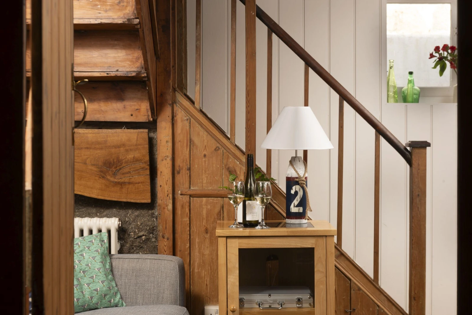 A side table with a lamp and stairs - No.1 St Eia