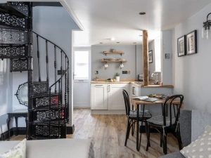 Open plan dining and kitchen area with stairs to upper floor - Apothecary Cottage