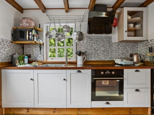 Kitchen area with hob and oven, microwave and slim dishwasher - Beryas Cottage