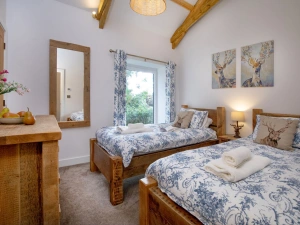 Twin beds in bedroom two, chest of drawers and bedside tables with lamps  - Longpark Linhay