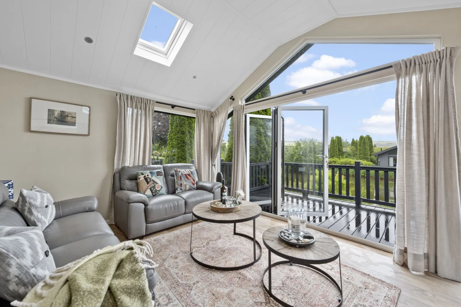 Living area with coffee table, sofas, TV, decking area with hot tub - Brayford Lodge, Kentisbury Grange