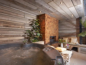 undercover hot tub, fireplace and seating within garden - Sandy Boobies