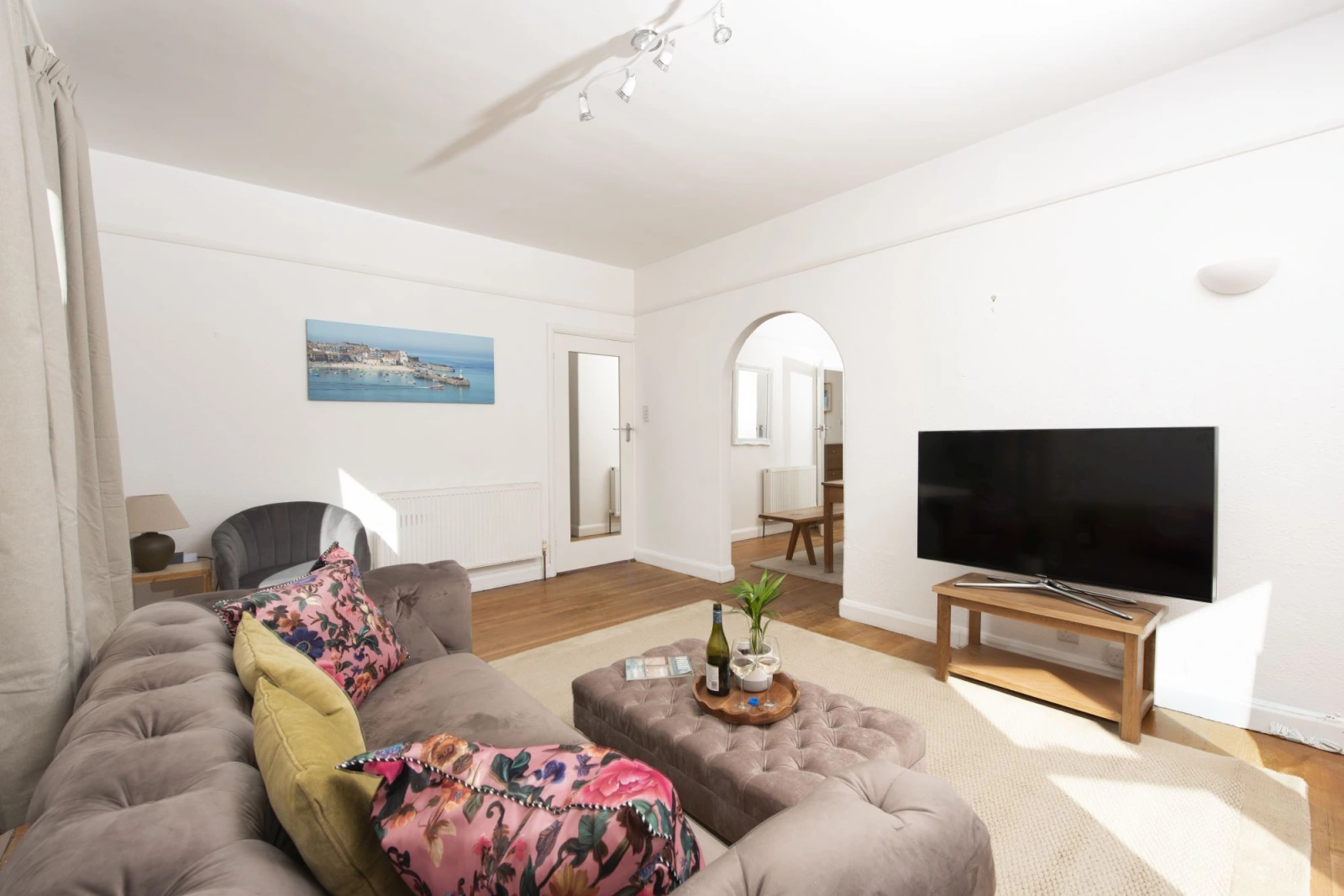 Living area accessed from dining area, seating, TV, mirror - Folneth