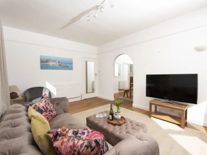 Living area accessed from dining area, seating, TV, mirror - Folneth