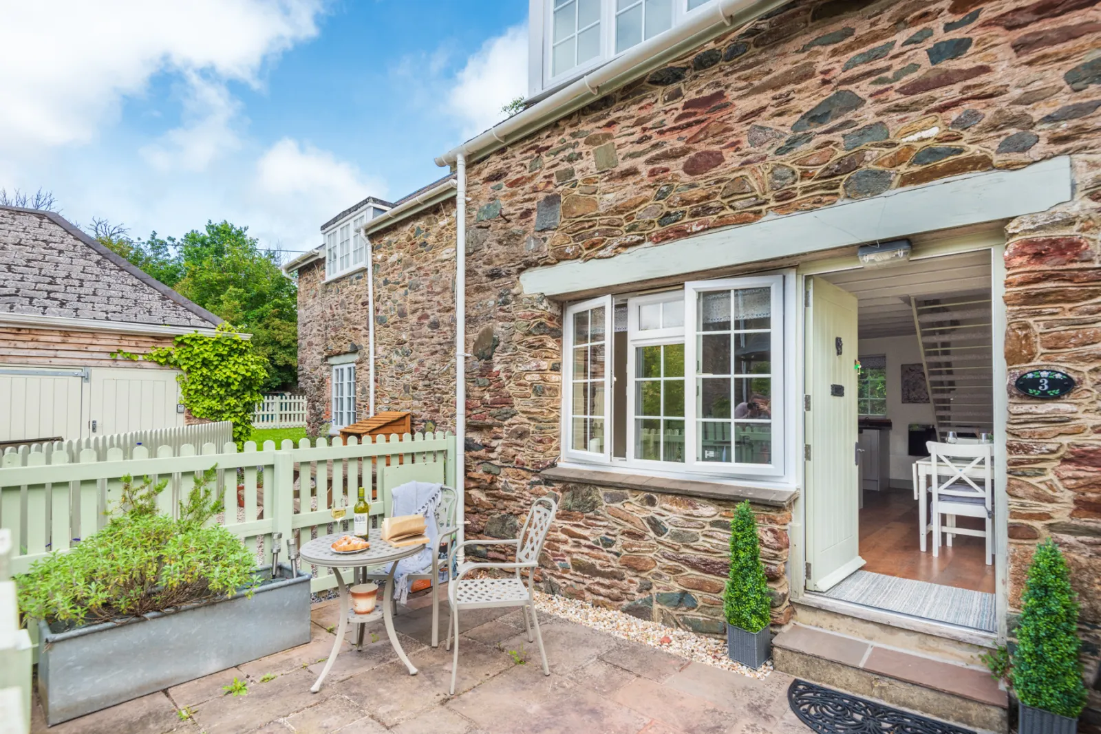 Paved patio with table and chairs, perfect for alfresco dining. 
