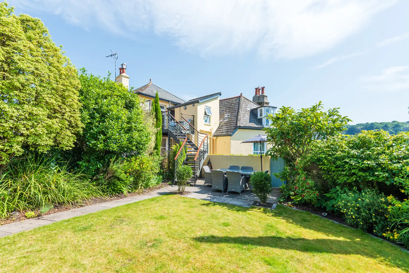 Private lawned garden with paved patio area.