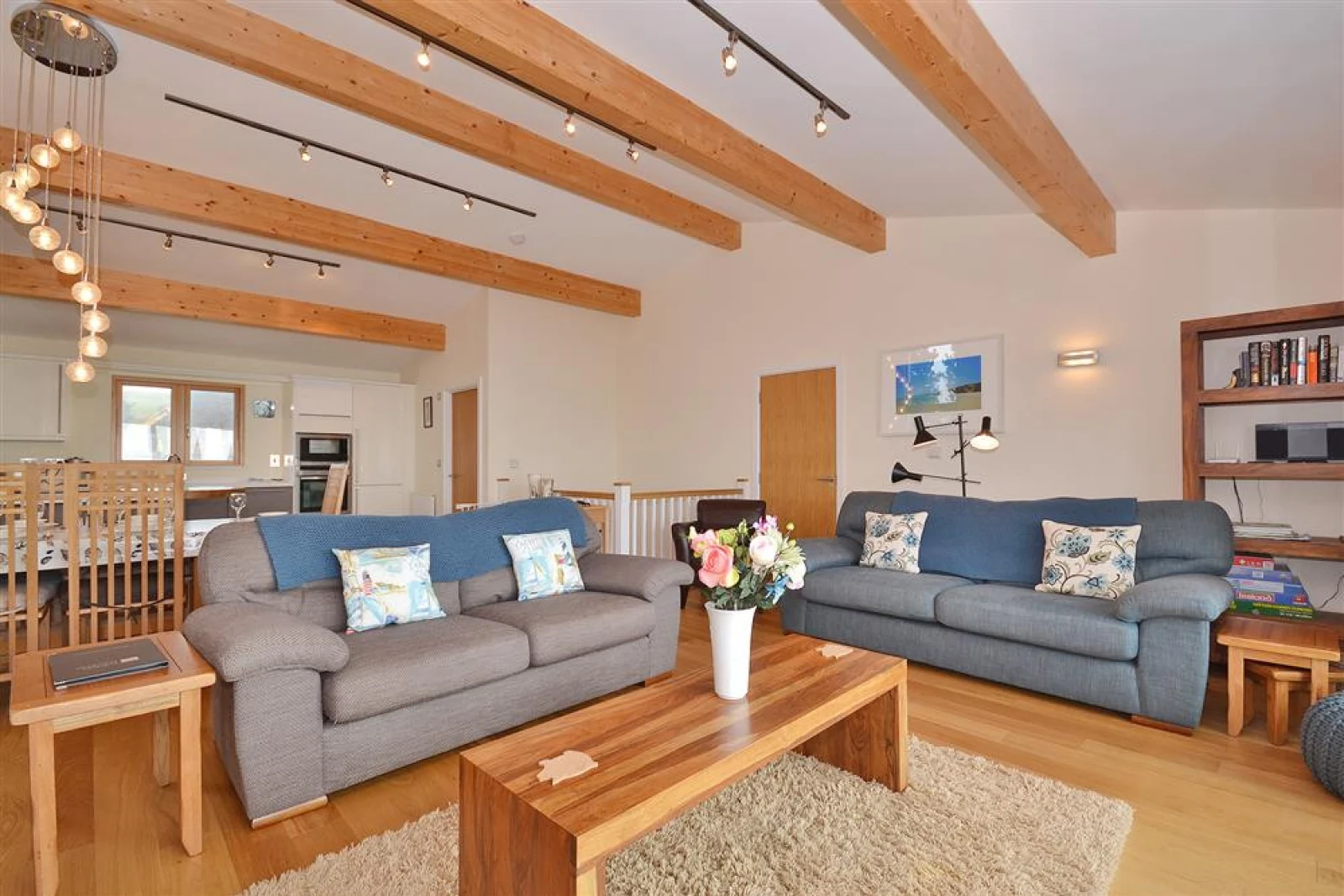 Another view of the living room, showing the kitchen and dining area behind