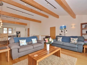 Another view of the living room, showing the kitchen and dining area behind