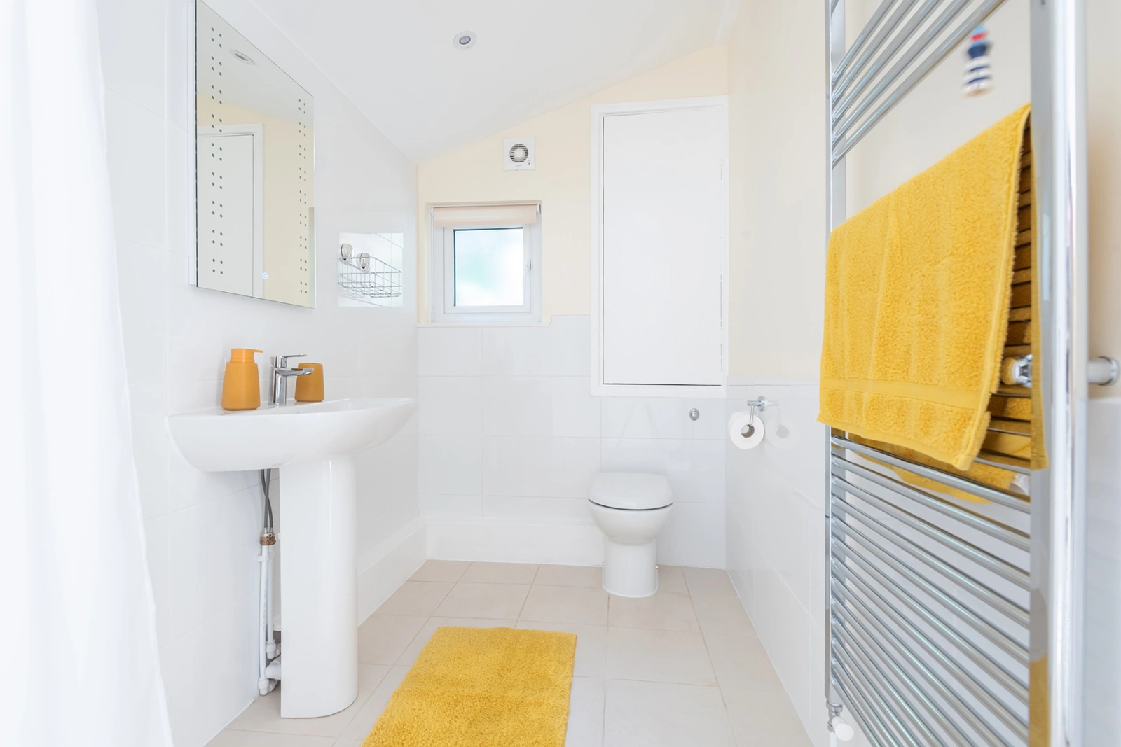 Brand new wet room with a tall heated towel rail and a splash of sunflower-yellow!