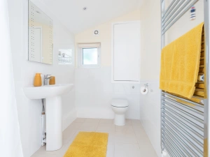 Brand new wet room with a tall heated towel rail and a splash of sunflower-yellow!