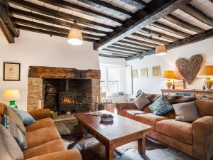 The gorgeous snug with beamed ceiling, slate floors, comfy sofas and log burner. 