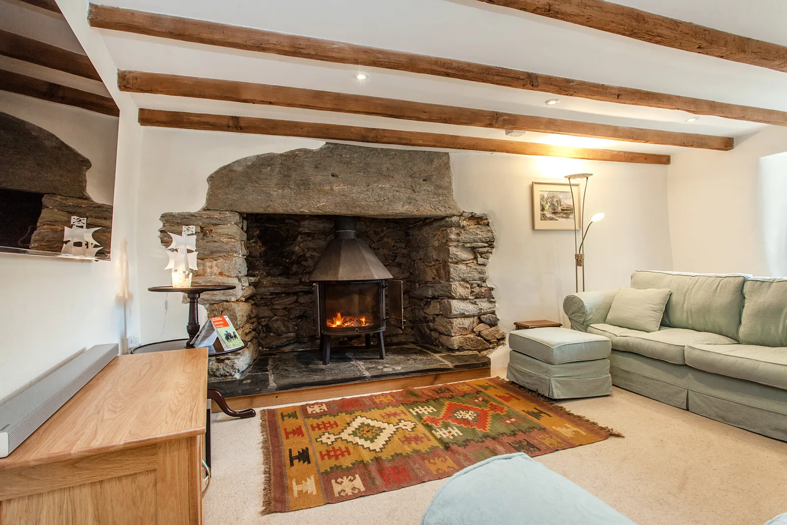 Large lounging area with log burner and 4K UHD TV.