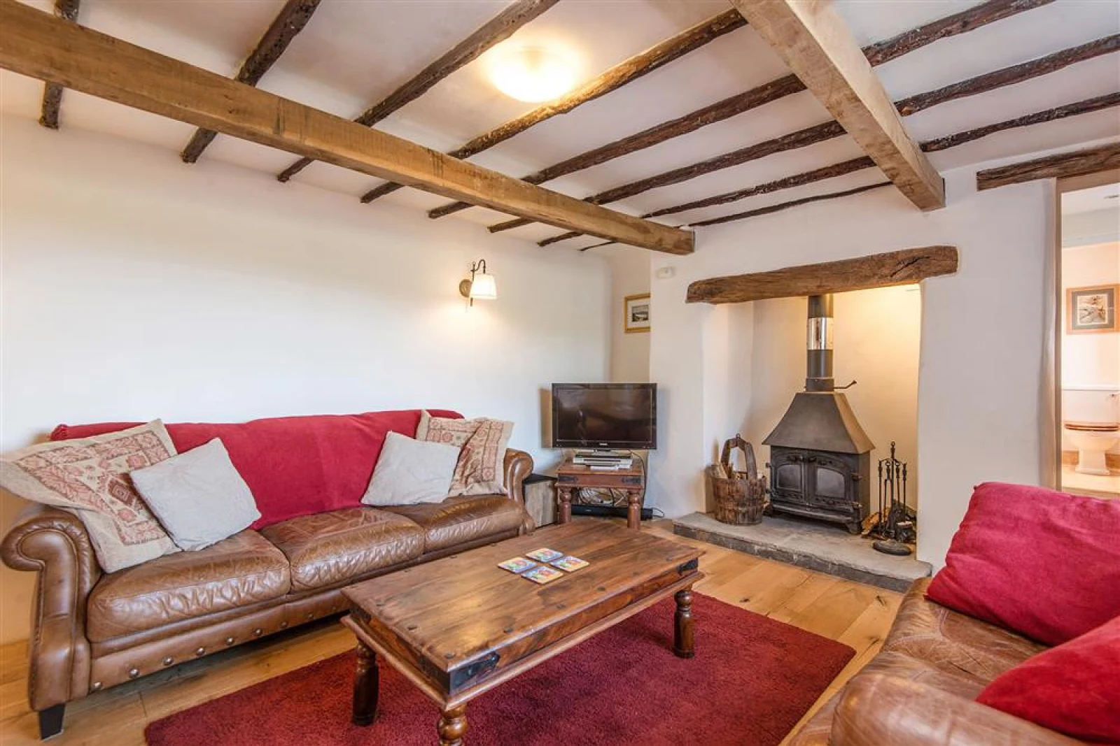 Cosy beamed sitting room with wood burner stove