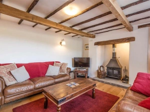 Cosy beamed sitting room with wood burner stove