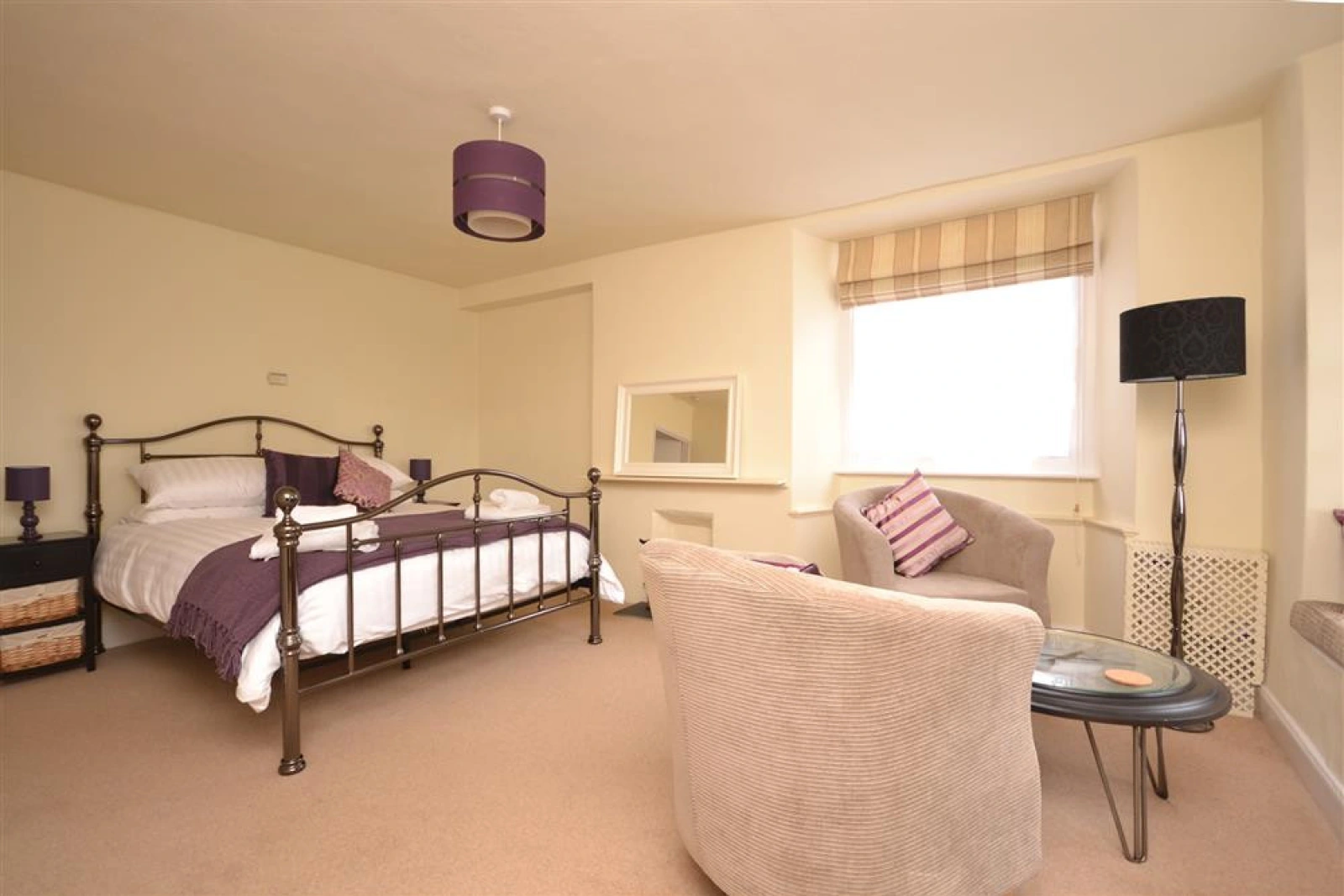 The spacious master bedroom with a seating area.