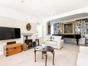 Lounge with seating for 8 with wood burning stove and piano for guests use.