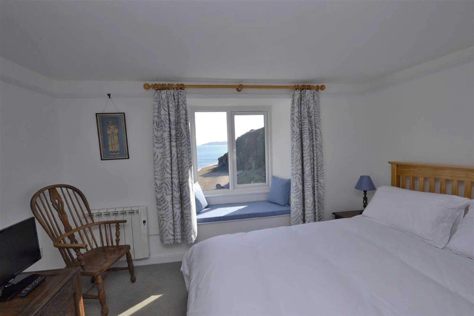 Bedroom 1 with views of the beach below and the sea.