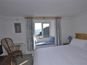 Bedroom 1 with views of the beach below and the sea.