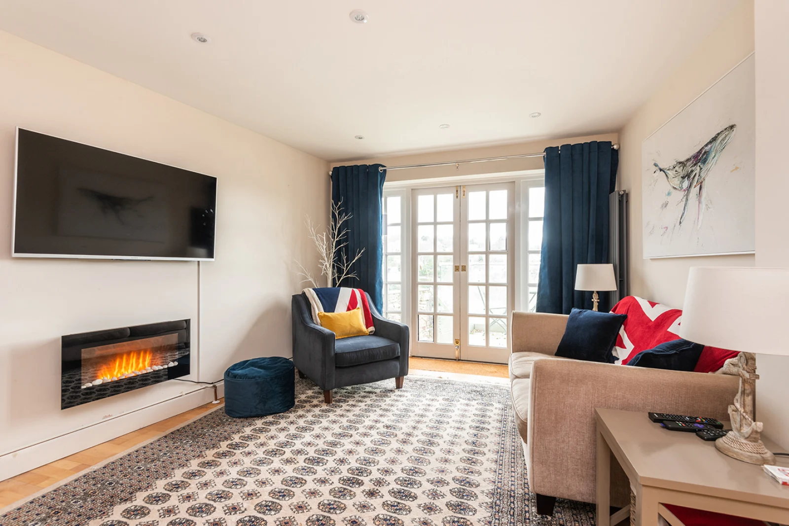 Smart television and doors to the garden. Immediate terrace area with seating for two.