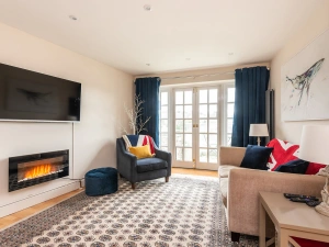 Smart television and doors to the garden. Immediate terrace area with seating for two.