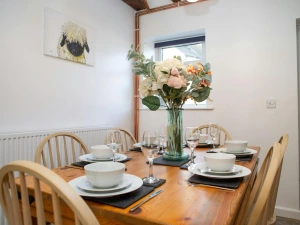 Dining table with six chairs laid for dinner
