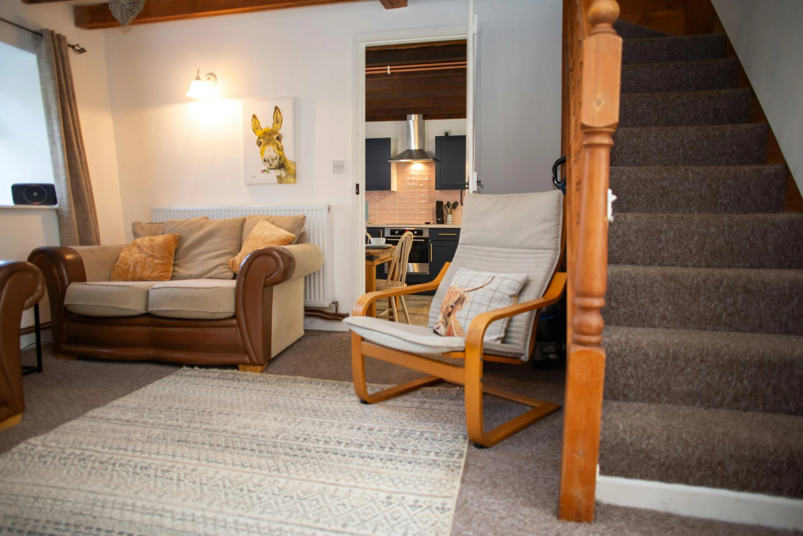 Stairs leading to the first floor bedrooms and bathroom; sofa and armchair