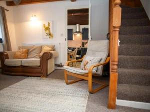 Stairs leading to the first floor bedrooms and bathroom; sofa and armchair