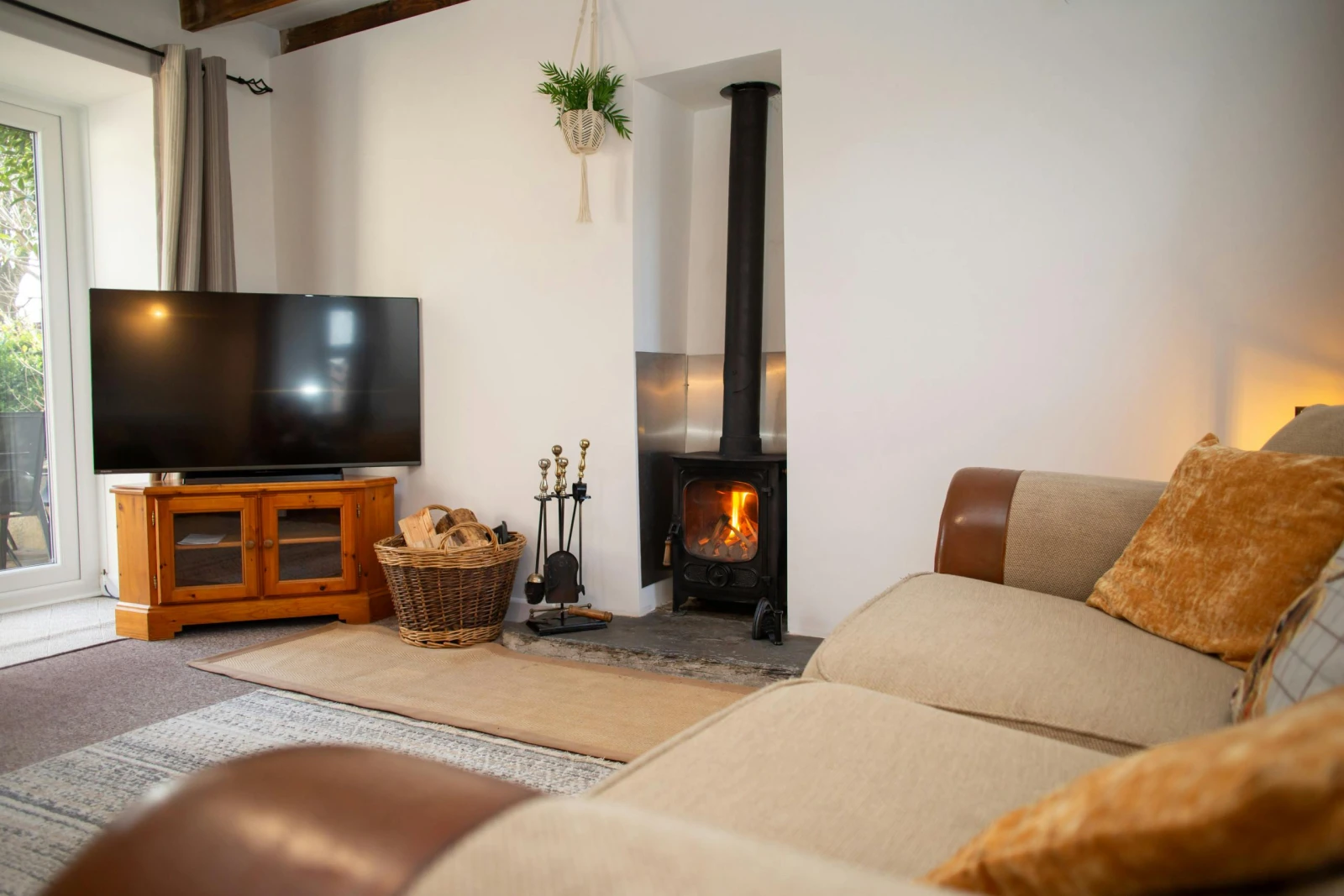 Sofa, TV on unit and wood burner