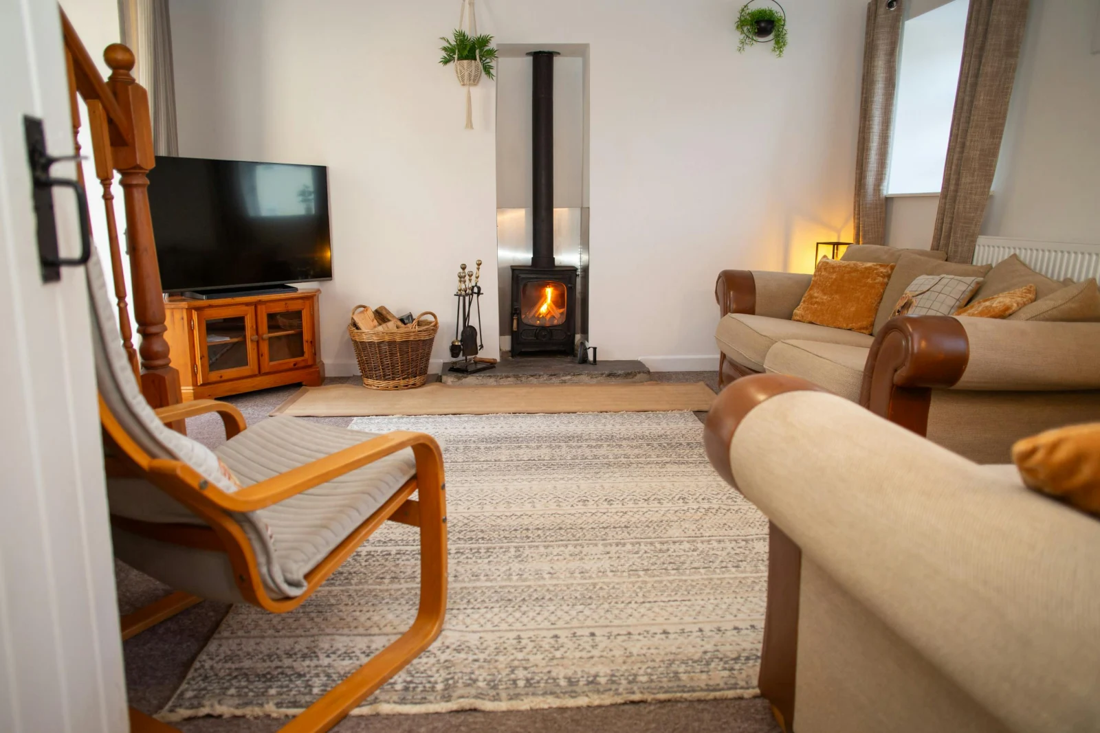 TV on unit, wood burner, sofas and armchair