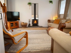 TV on unit, wood burner, sofas and armchair