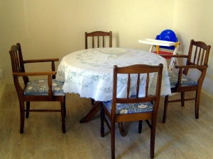 Extra seating in the kitchen diner with circular dining table, four chairs and child's highchair