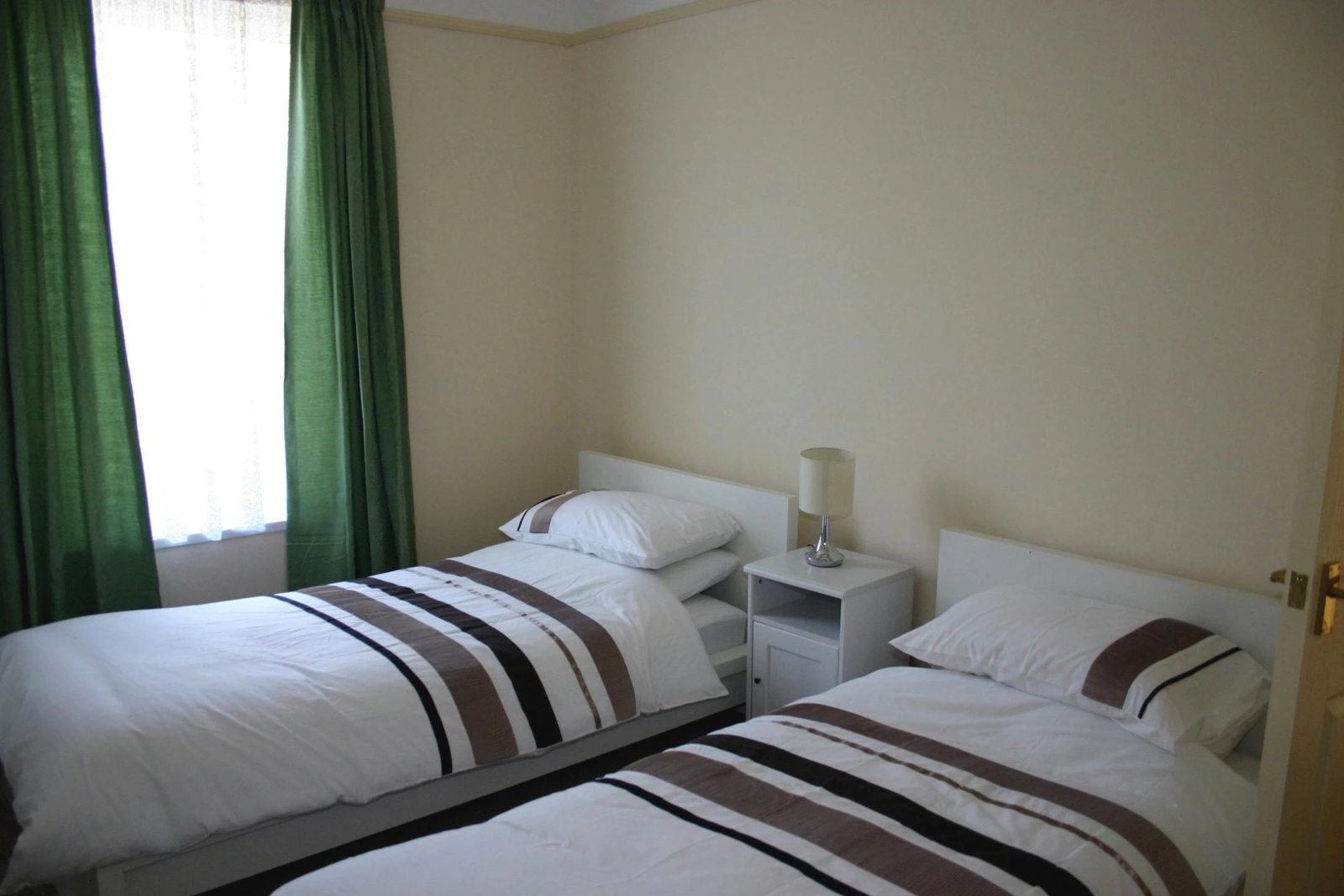 Twin single beds, bedside cabinet with a lamp