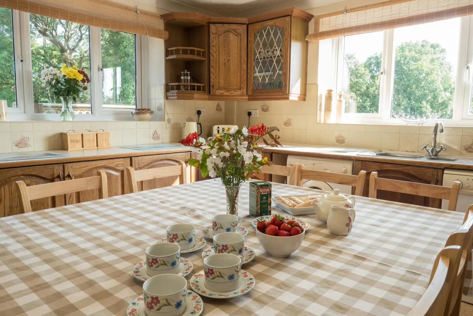 Kitchen table and chairs set for tea, two large windows