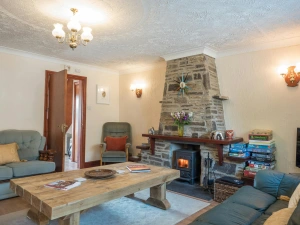 Stone fireplace with wood burner, coffee table and sofas and armchairs