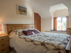 Double bed, bedside chest of drawers with lamp, larger chest of drawers and window