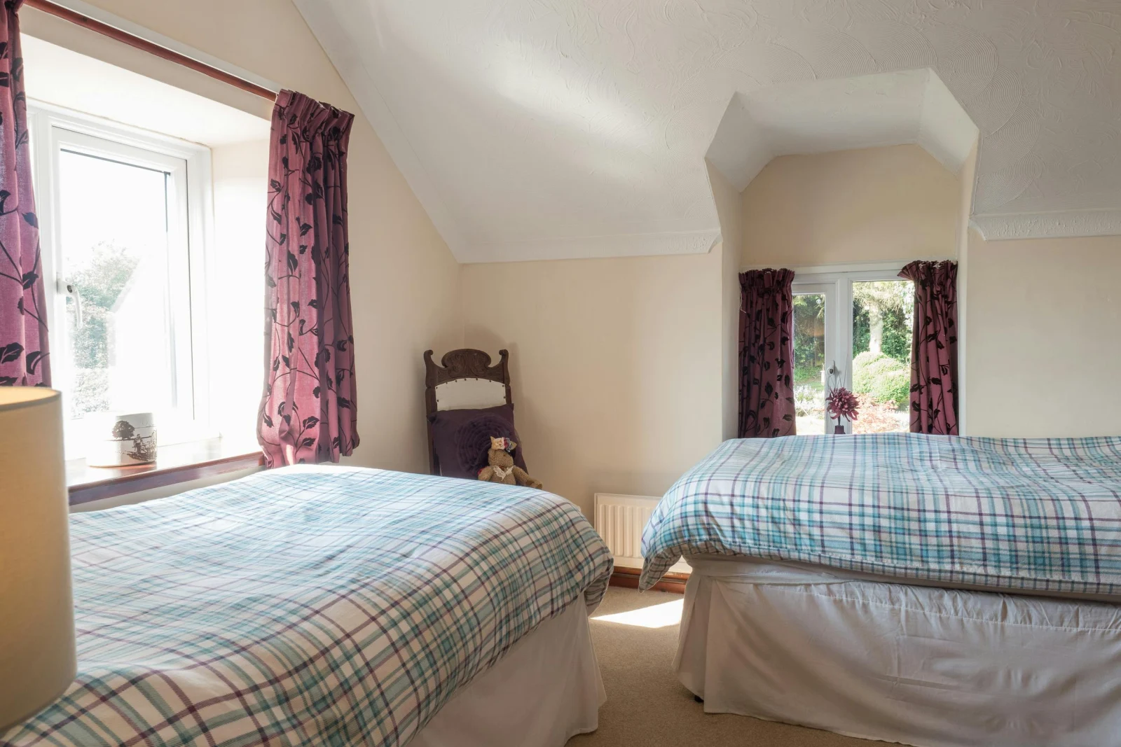 Twin single beds, chair, radiator and two windows