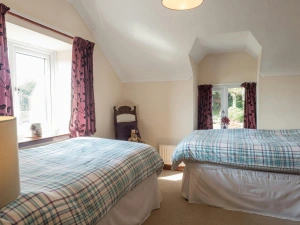 Twin single beds, chair, radiator and two windows