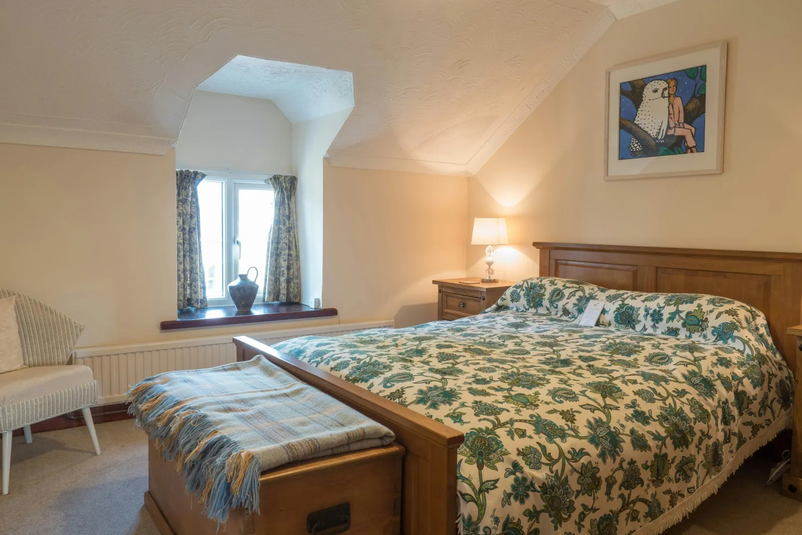 Master double bedroom, bedside cabinets with lamps, wooden chest, chair, radiator and window