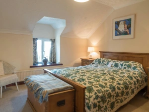 Master double bedroom, bedside cabinets with lamps, wooden chest, chair, radiator and window