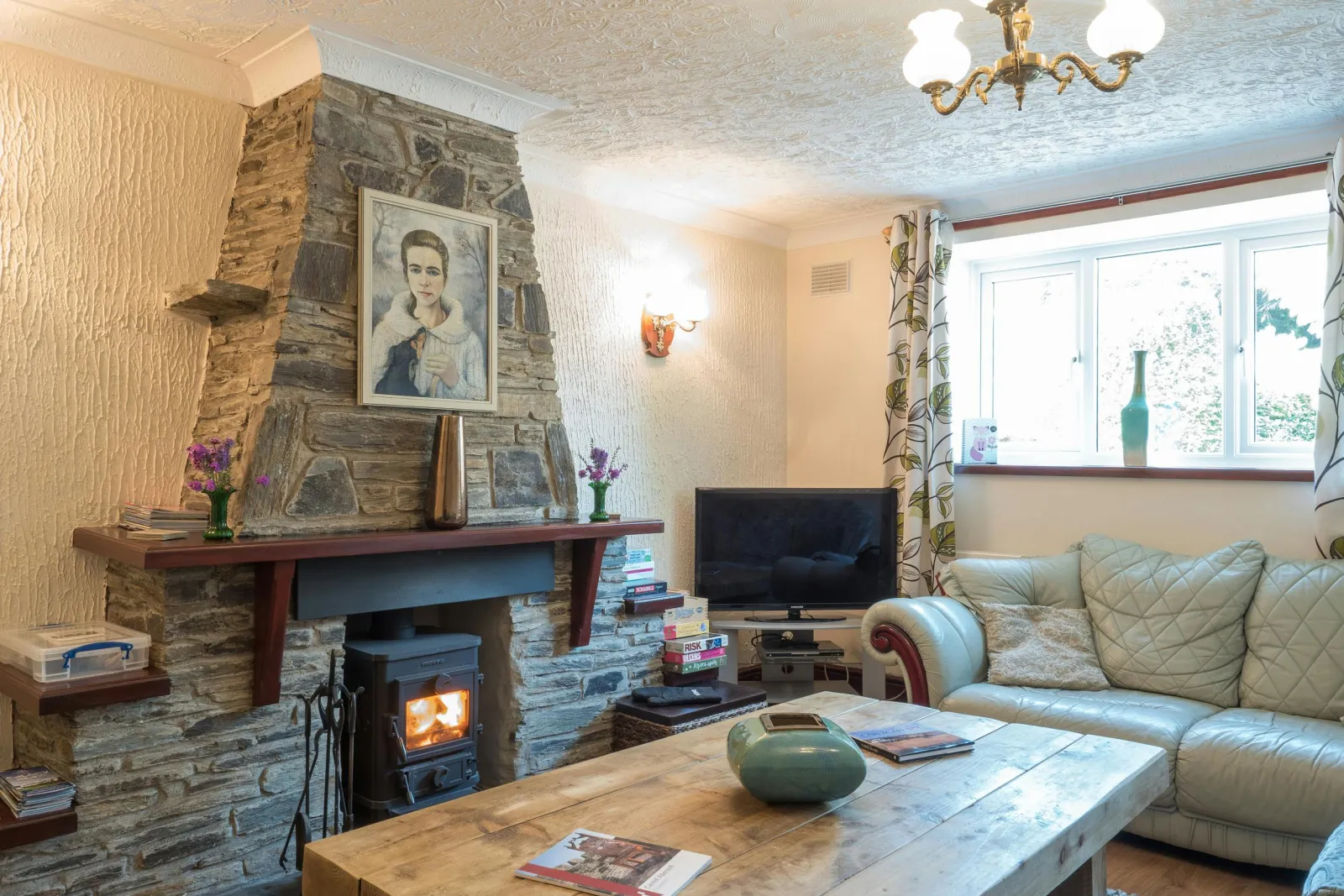Lounge in Oaktree Cottage, log burning stove, sofa, coffee table, TV and window